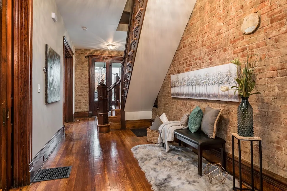 Renovated interior hallway with exposed brick walls and hardwood floors