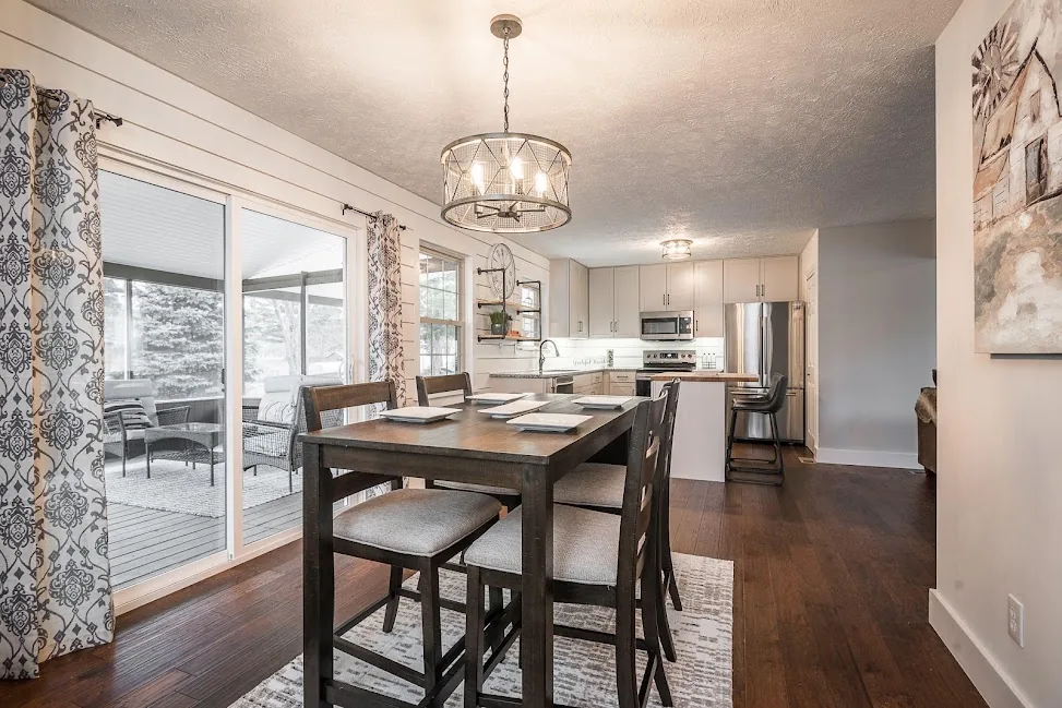 Renovated kitchen and dining area with white cabinets and hardwood floors